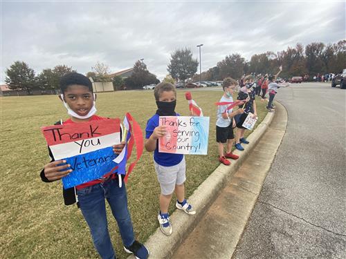 kids along parade route holding flags 